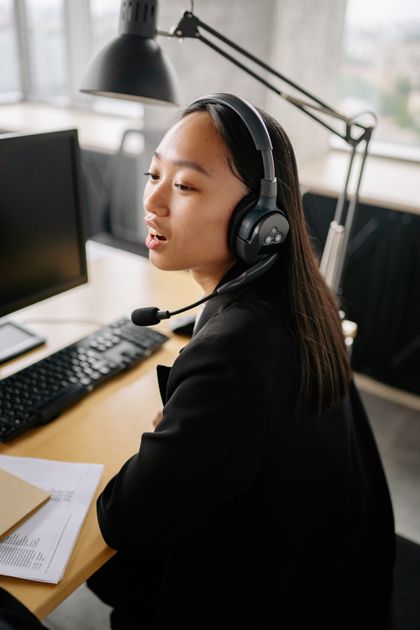 A customer support agent wearing a headset at a help desk.