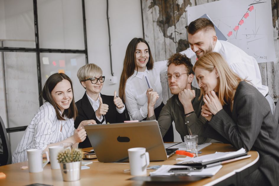 A team gathered around a laptop during a meeting.