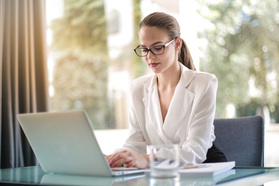 A small business owner working on a laptop at her workspace.