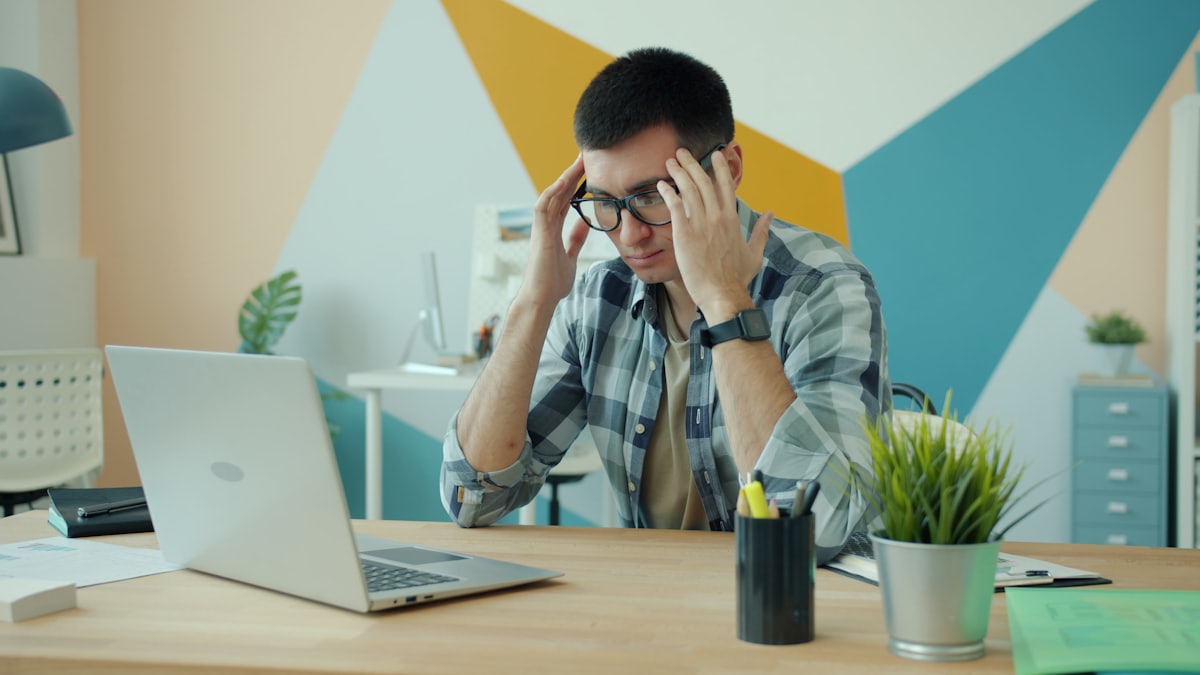 A person holds their head in frustration at a laptop, illustrating a disappointing AI answer.