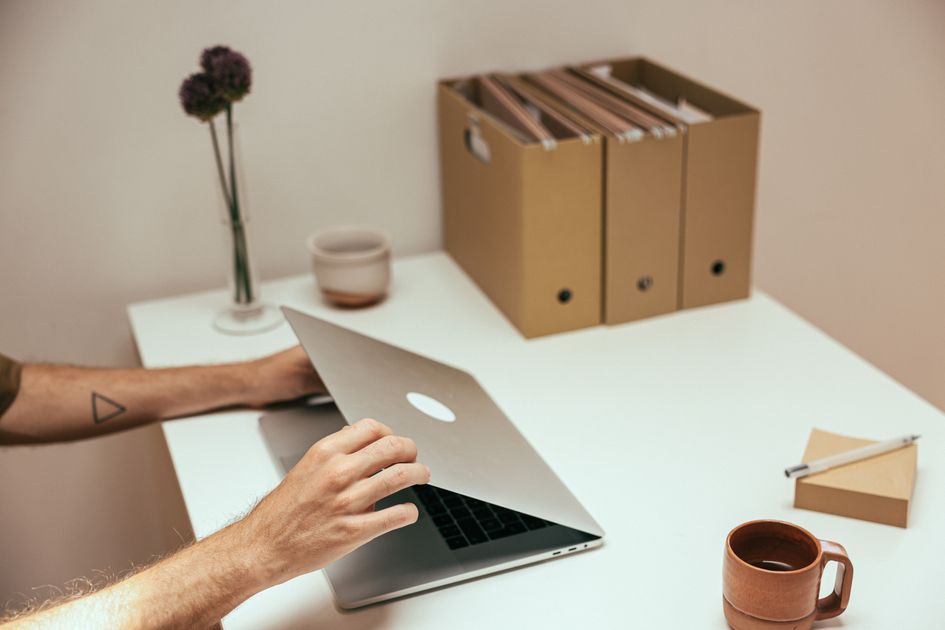 A laptop, coffee mug, and notebook arranged neatly on a desk, suggesting an organized workflow versus scattered copy-paste.