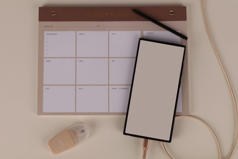 A minimalist desk with a weekly planner and neatly arranged stationery, symbolizing an organized prompt system.