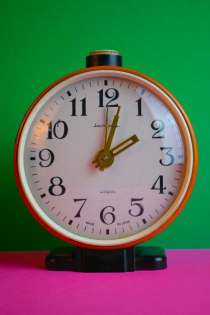 A desk clock beside a tidy workspace, emphasizing the time saved by reusing ready-made prompt templates.